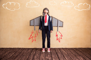 Portrait of young businessman with toy paper wings. Success, creative and startup concept. Copy space for your text