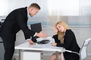 51090664 - boss shouting at female employee sitting at desk in office
