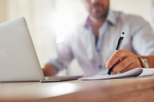 Young business man hands writing notes