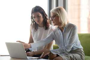 Serious middle aged executive manager explaining colleague online work